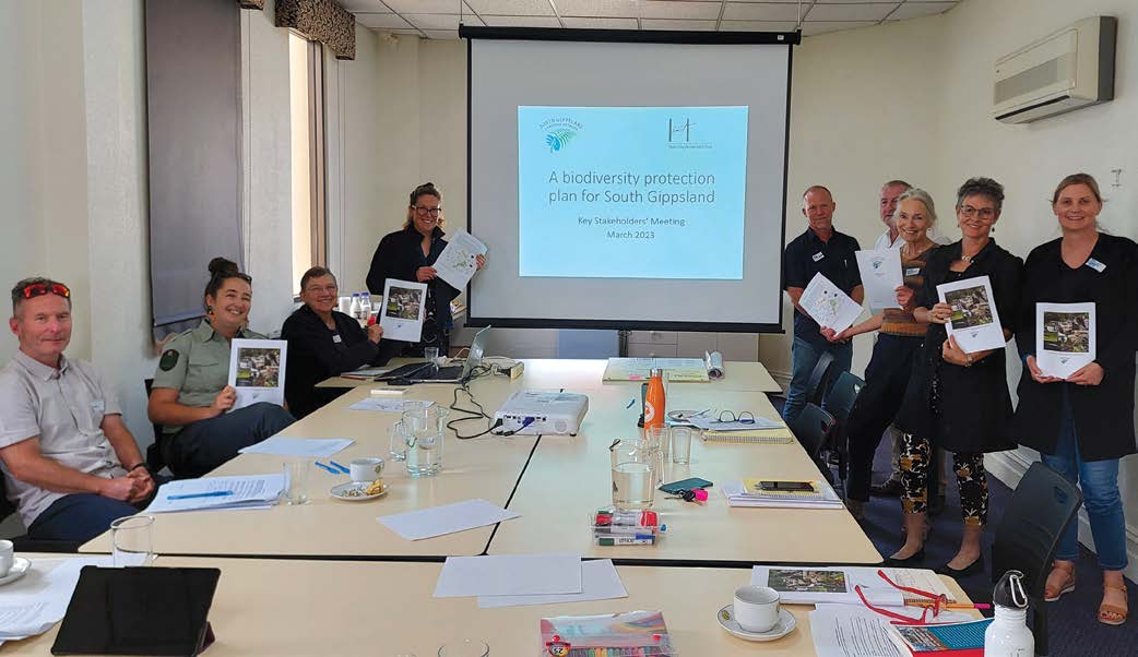 Members of the key stakeholder working group holding copies of the plan in a meeting room